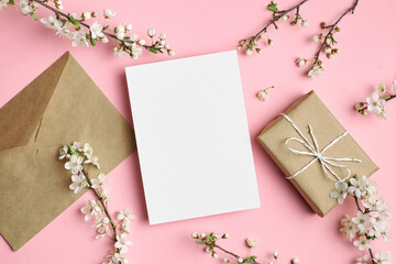 Greeting card mockup with gift and white flowers