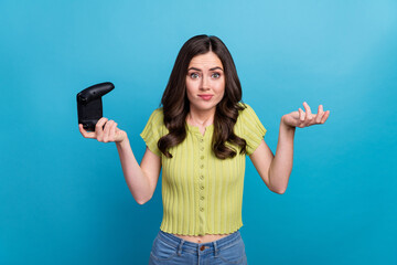 Photo of unsure millennial brunette lady playstation wear green t-shirt isolated on blue background © deagreez