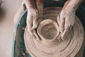 man's Hands careful and lovely hold woman's hands. couple works on potter's wheel. studio on modeling bowl from white clay. Top view. Concept of creative, skill and handmade