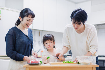 子供と一緒にクッキングをする家族