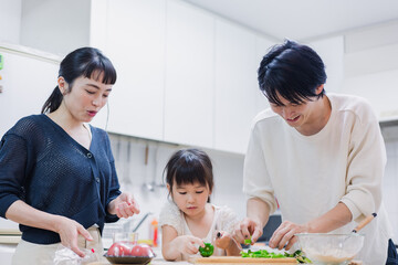 子供と一緒にクッキングをする家族