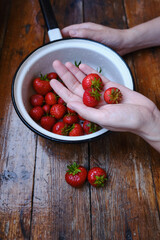 Bowl of fresh organic strawberries on a wooden background. Ripe farm fruits. Seasonal berries. Healthy food, vitamins. Bioproducts selected by hand