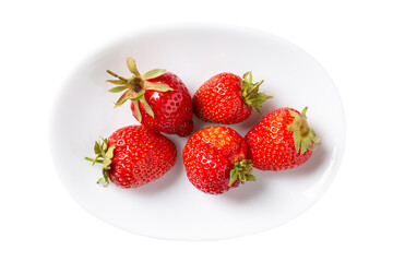 Strawberry berries on white plate isolated on white background. Top view, close-up.