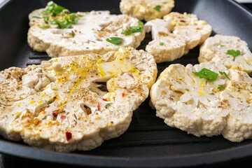 Cauliflower steaks cooking. Healthy eating, plant based meat substitute concept. Vegetarian organic food.