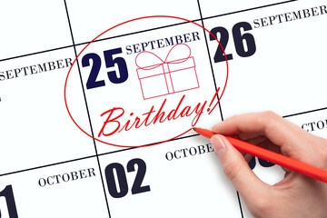 The hand circles the date on the calendar 25 September , draws a gift box and writes the text...