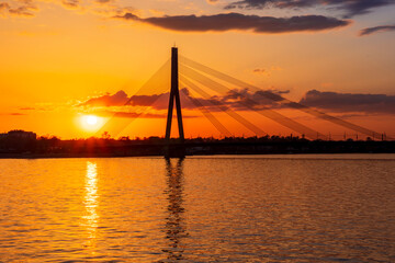 picturecque view from water surface to large river and cable - stayed bridge