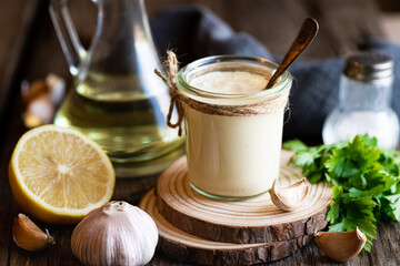 Aioli sauce on a wooden background, selective focus - obrazy, fototapety, plakaty