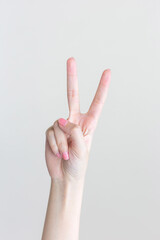 Beautiful female hand shows finger as a pointing symbol in manicure concept to present something on the white background.