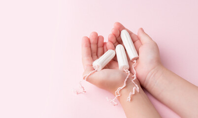 Tampons in female hands. Lack of feminine hygiene products