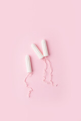 Menstrual tampons on a pink background. Menstruation time. Hygiene and protection for woman. Lack of feminine hygiene products