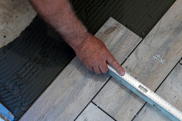 Ceramic tile. The tiler lays ceramic tiles on the adhesive.