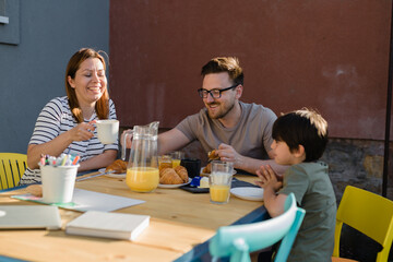family breakfast together outdoor in home backyard