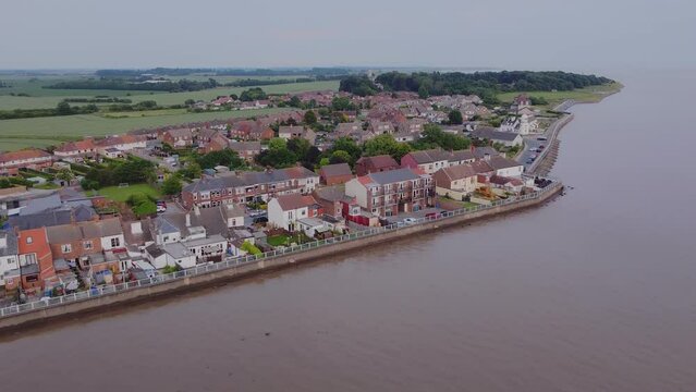 Drone shot mavic mini 2. Coastal flood defenses, English coastal village, houses, suburban. Filmed Yorkshire. England. 16.6.2022