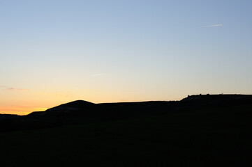 two planes air traffic at sunset with silhouettes of mountains.  Photography with copy space. Low key photograph