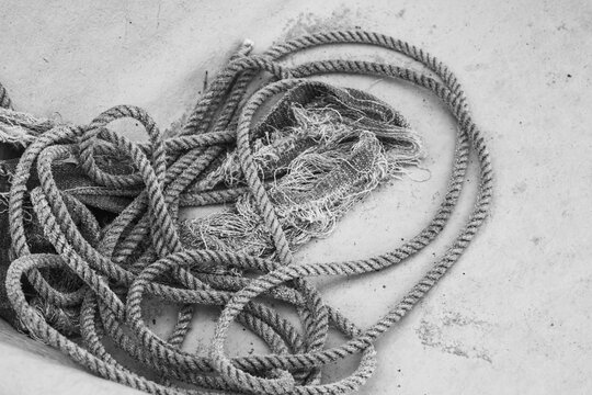 Closeup of coil of nautical rope on fishing boat hull.