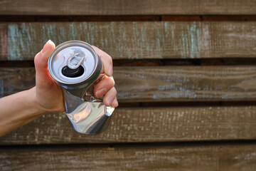 Crumpled tin can in hand. Recyclable material. Environmental protection. Zero waste. Used beverage...