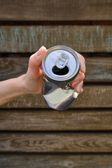 Crumpled tin can in hand. Recyclable material. Environmental protection. Zero waste. Used beverage containers
