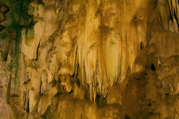 Natural dark underground cave with strangely shaped stalactites.