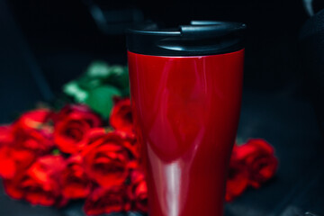 Thermo mug with flowers on the table