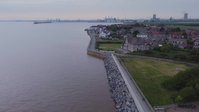 Drone shot. Coastal flood defenses, English coastal village, houses, suburban. Filmed Yorkshire. England.