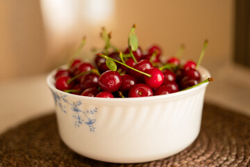 Red summer cherries in a white bowl.