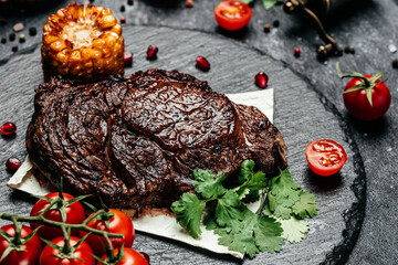 Prime Black Angus Ribeye steak with corn and cherry tomatoes. banner, menu, recipe place for text, top view