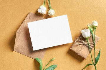 Greeting card mockup with gift box and white flowers