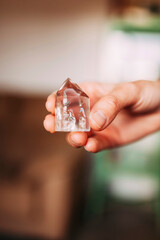Beautiful woman hand holding little quartz crystal indoors, healing crystal concept shoot, can be used as background.