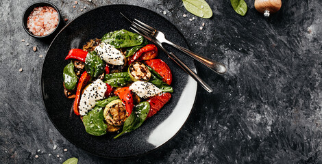 Delicious salad with roasted bell pepper, zucchini, eggplant with spinach leaves and feta cheese. Restaurant menu, dieting, cookbook recipe top view