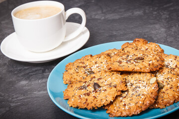 Cup of coffee with milk and fresh baked healthy oatmeal cookies. Delicious crunchy dessert