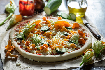 Ingredients for vegetarian pizza with tomato sauce and fresh vegetables.
