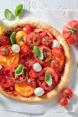 Healthy and vegetarian pizza Margherita with various tomatoes and mozzarella.