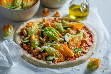 Preparations for homemade pizza made of mushrooms and zucchini flower.