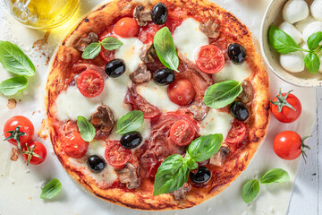 Tasty pizza Capricciosa made of tomatoes, olives, cheese and ham.