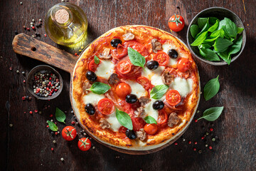 Tasty and healthy pizza Capricciosa with prosciutto, mushrooms and cheese.