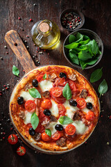 Homemade and hot pizza Capricciosa with prosciutto, mushrooms and cheese.