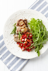 Grilled Pork Tenderloin with Tomato Salsa and Arugula. Bright background. Top view. Copy space. 	