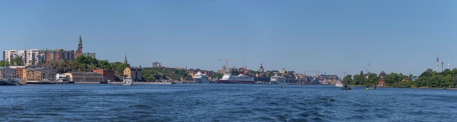 Fototapeta na wymiar Panorama view over the bay Saltsjön with apartment houses in the district Nacka commuting boats and cruise ships a sunny summer day in Stockholm 