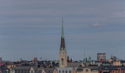Fototapeta na wymiar Roofs and the church tower of Oscars Kyrkan in the district Östermalm a sunny summer day in Stockholm