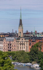 The church Oscars Kyrkan in the district Östermalm, a canal with day cruiser boats a sunny summer day in Stockholm