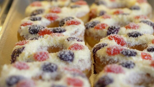 delicious purple donuts lie on a glass display case. Close up