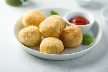 Traditional homemade arancini balls with tomato sauce