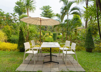 Obraz premium Relax table, chairs and umbrellas in park garden. Outdoor restaurant