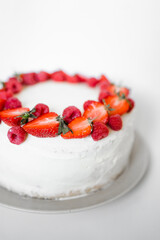 Delicious biscuit cake with cream cheese and berries. Light cake with strawberries and raspberries. Handmade cake. close up, copy space background. Selective focus