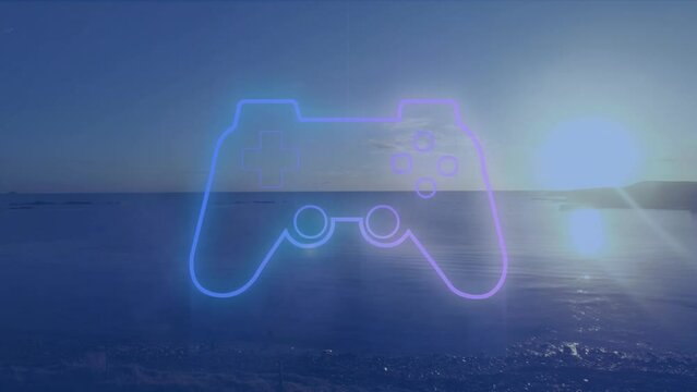 Videogame controller icon against view of sunset sky over the sea