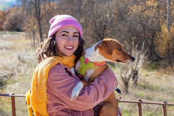 Mujer con perro en el campo. Mujer con ropa rosa en la montaña. Estilo de vida. Mujer sonriendo