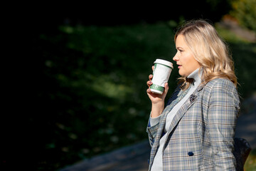 Wonderful moments of relaxation with recyclable cup of hot drink in city park on sunny autumn day...