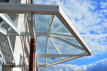 Glas-Vordach mit Metallrahmen an einem modernen Gebäude