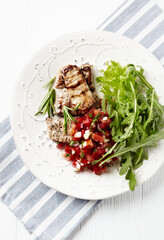 Grilled Pork Tenderloin with Tomato Salsa and Arugula. Bright background. Top view. Copy space.