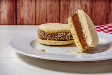 Argentine classic alfajores of cornstarch and dulce de leche with coconut on a vintage plate. Landscape Orientation. sweet snack